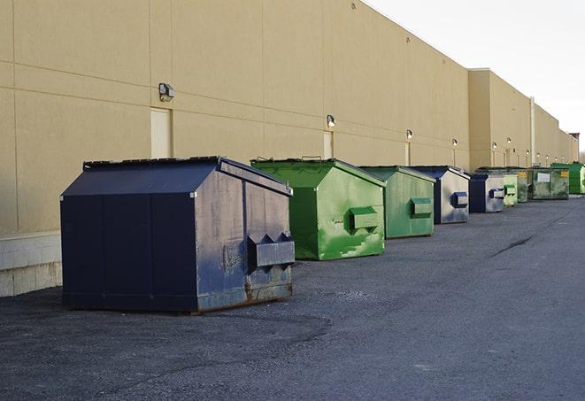 a construction worker moves construction materials near a dumpster in Austinburg